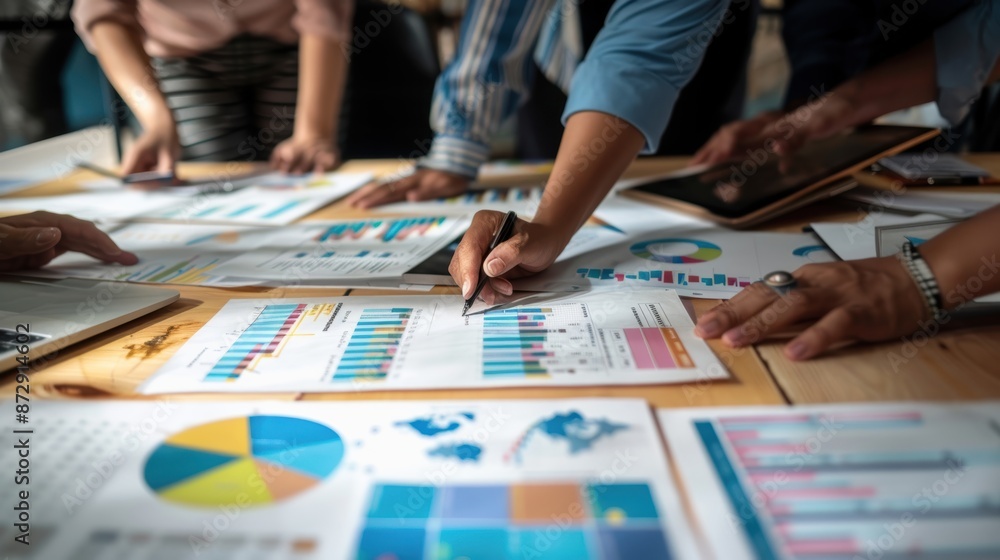 Diverse team brainstorming over budget charts, analysis, business strategy Diverse team brainstorming over budget charts, analysis, business strategy