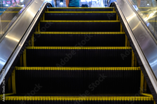 Close up view of an escalator with yellow safety edges, highlighting its steps and modern design.