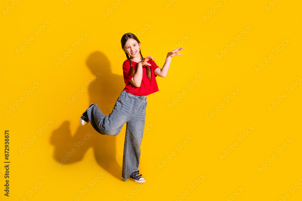Full length portrait of cute little girl arms scare empty space wear t-shirt isolated on yellow color background Full length portrait of cute little girl arms scare empty space wear t-shirt isolated on yellow color background
