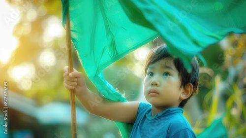 Boy in blue shirt holding green flag photography 