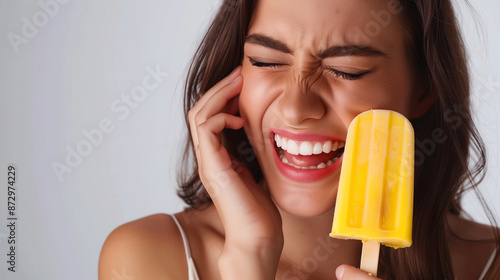 Woman Experiencing Toothache While Eating Popsicle photo