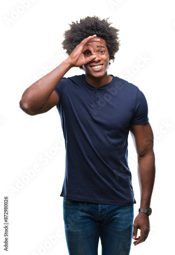 Afro american man over isolated background doing ok gesture with hand smiling, eye looking through fingers with happy face.