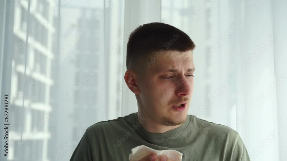 A man with a cold blows his nose into a napkin.
The man fell ill with the flu and had a severe runny nose.
Stuffy nose.