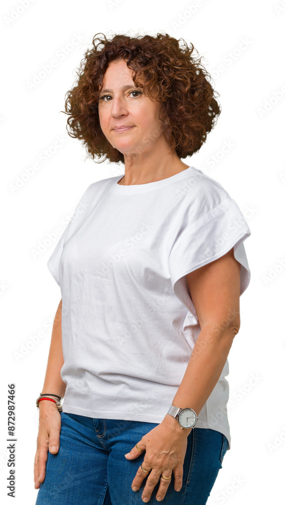 Beautiful middle ager senior woman wearing white t-shirt over isolated background Relaxed with serious expression on face. Simple and natural with crossed arms Beautiful middle ager senior woman wearing white t-shirt over isolated background Relaxed with serious expression on face. Simple and natural with crossed arms