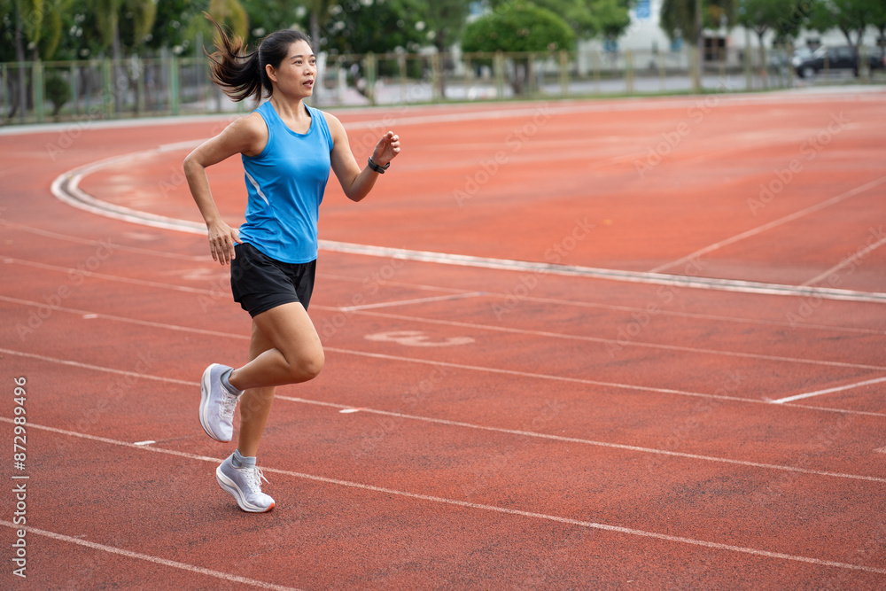 Fototapeta premium Asia mature woman Runner drill training on race track and field 