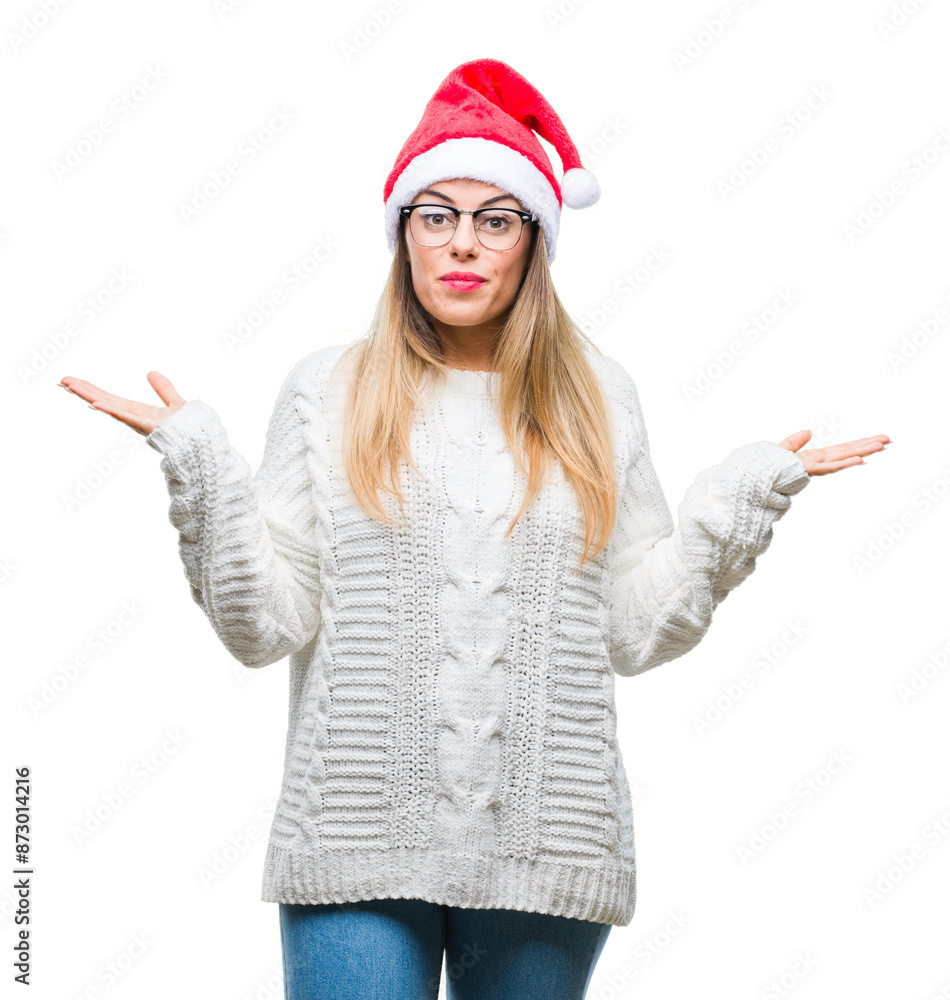 Young beautiful woman wearing christmas hat over isolated background clueless and confused expression with arms and hands raised. Doubt concept. Young beautiful woman wearing christmas hat over isolated background clueless and confused expression with arms and hands raised. Doubt concept.