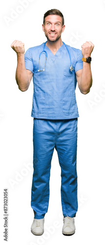 Handsome doctor man wearing medical uniform over isolated background celebrating surprised and amazed for success with arms raised and open eyes. Winner concept.