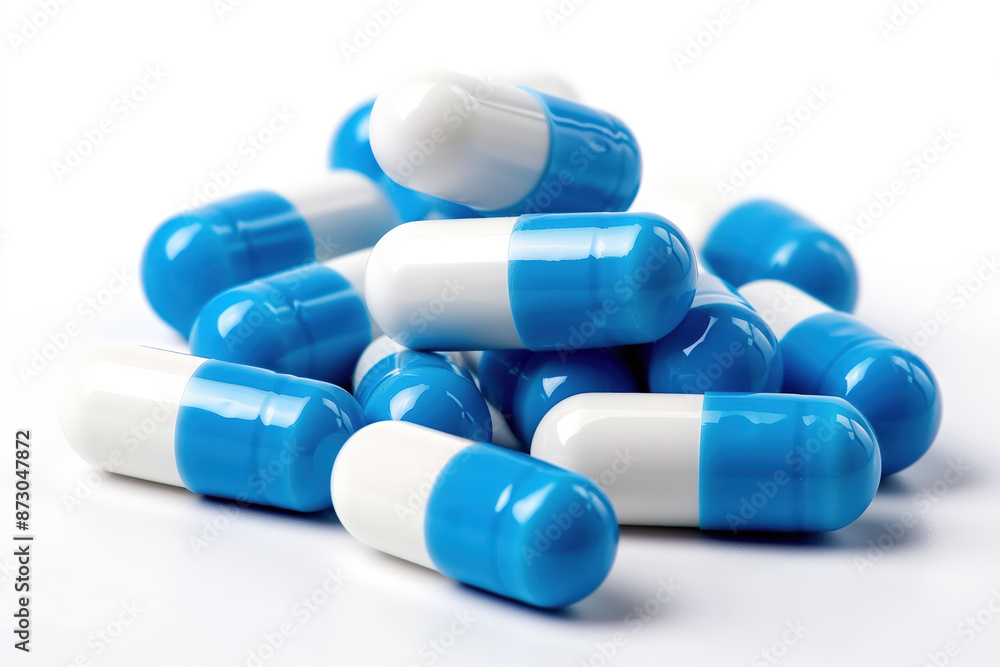 Blue and white pills stacked on an isolated white background. Blue and white pills stacked on an isolated white background.