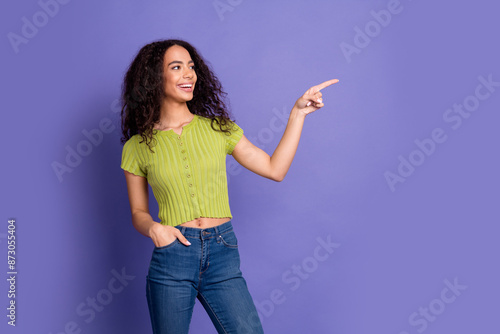 Photo portrait of lovely teen lady point look empty space dressed stylish green garment isolated on purple color background