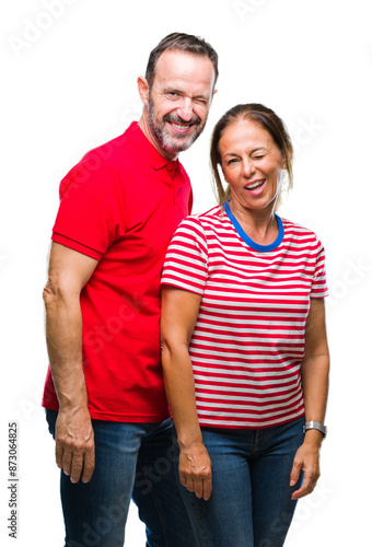 Middle age hispanic couple in love over isolated background winking looking at the camera with sexy expression, cheerful and happy face.