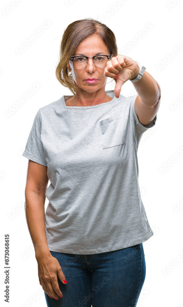 Fototapeta premium Middle age senior hispanic woman wearing glasses over isolated background looking unhappy and angry showing rejection and negative with thumbs down gesture. Bad expression.
