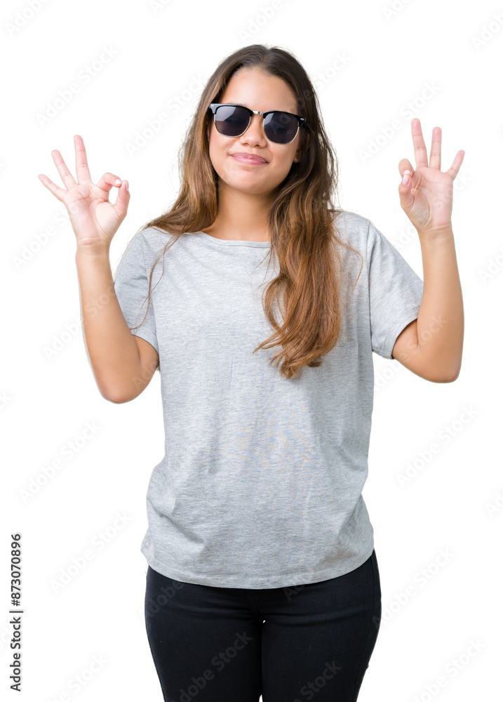 Young beautiful brunette woman wearing sunglasses over isolated background relax and smiling with eyes closed doing meditation gesture with fingers. Yoga concept. Young beautiful brunette woman wearing sunglasses over isolated background relax and smiling with eyes closed doing meditation gesture with fingers. Yoga concept.
