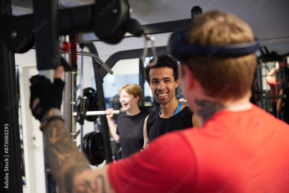 Smiling man talking with friend in gym Smiling man talking with friend in gym