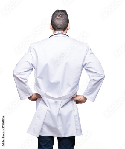 Handsome young doctor man over isolated background standing backwards looking away with arms on body