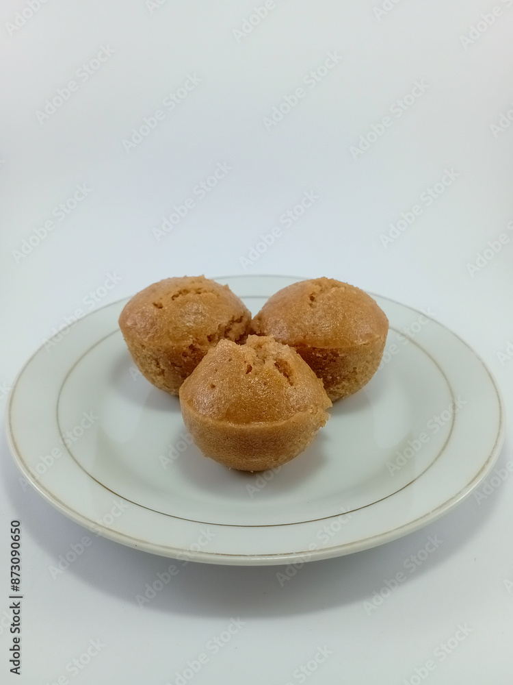 Kue Apem: Indonesian Steamed Sweet Dessert with White Brown Sugar or White Sugar, Showcasing Traditional Culinary Heritage on a Clean White Background Kue Apem: Indonesian Steamed Sweet Dessert with White Brown Sugar or White Sugar, Showcasing Traditional Culinary Heritage on a Clean White Background