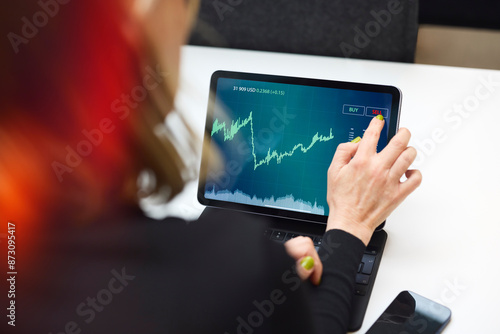 Businesswoman trading through tablet PC at office