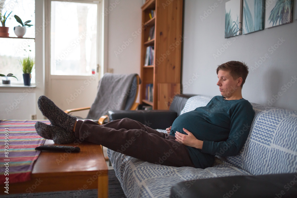 Full length of pregnant woman resting on sofa at home Full length of pregnant woman resting on sofa at home