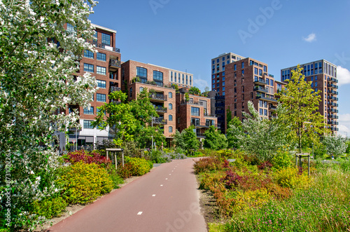 Rotterdam, The Netherlands, June 19, 2024: bicycle path through Tuschinski Park with Little C neighbourhood in the background