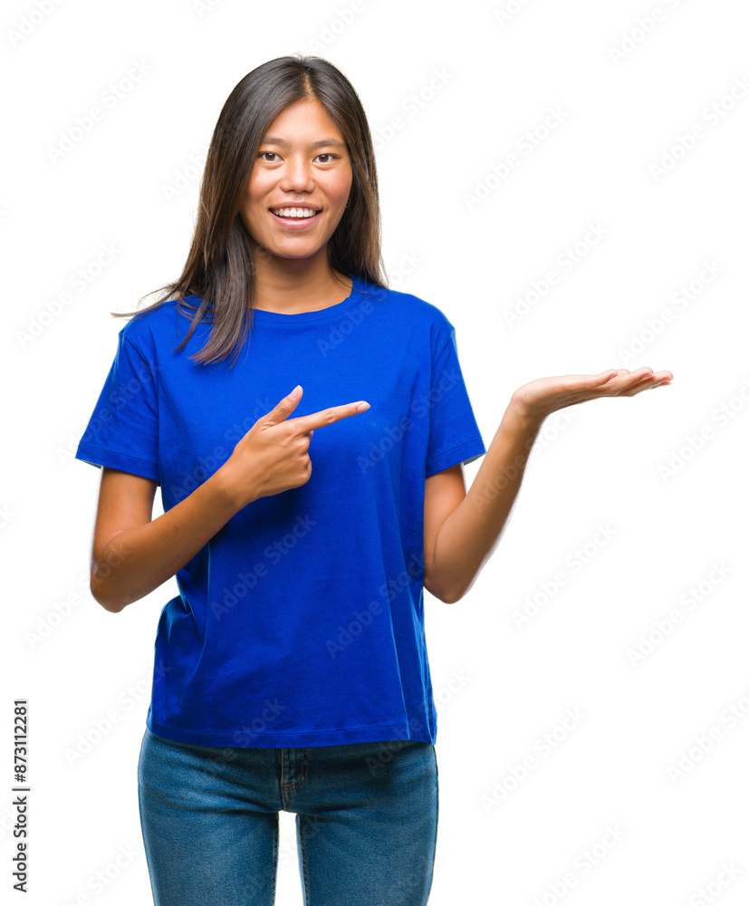 Young asian woman over isolated background amazed and smiling to the camera while presenting with hand and pointing with finger. Young asian woman over isolated background amazed and smiling to the camera while presenting with hand and pointing with finger.