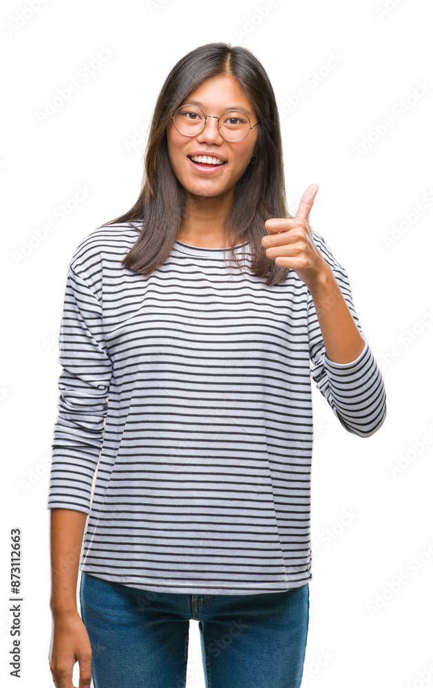 Young asian woman wearing glasses over isolated background doing happy thumbs up gesture with hand. Approving expression looking at the camera with showing success. Young asian woman wearing glasses over isolated background doing happy thumbs up gesture with hand. Approving expression looking at the camera with showing success.