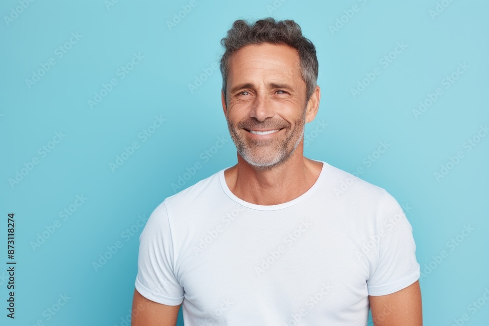 Portrait of a satisfied man in his 40s donning a trendy cropped top over pastel blue background Portrait of a satisfied man in his 40s donning a trendy cropped top over pastel blue background