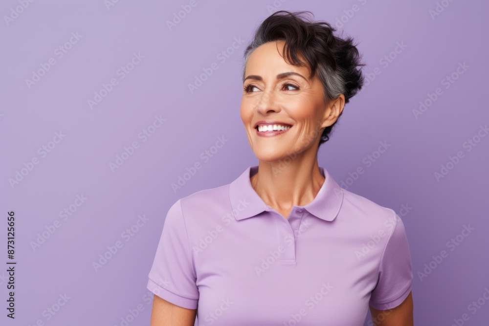 Portrait of a blissful woman in her 40s wearing a sporty polo shirt isolated in pastel purple background Portrait of a blissful woman in her 40s wearing a sporty polo shirt isolated in pastel purple background