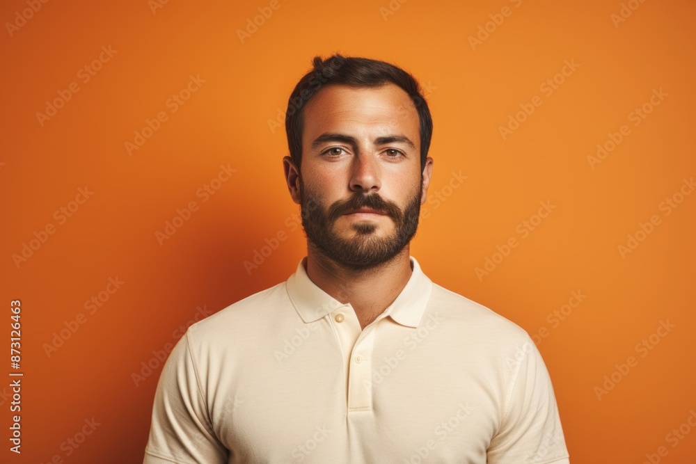 Portrait of a blissful man in his 30s donning a classy polo shirt on pastel orange background Portrait of a blissful man in his 30s donning a classy polo shirt on pastel orange background