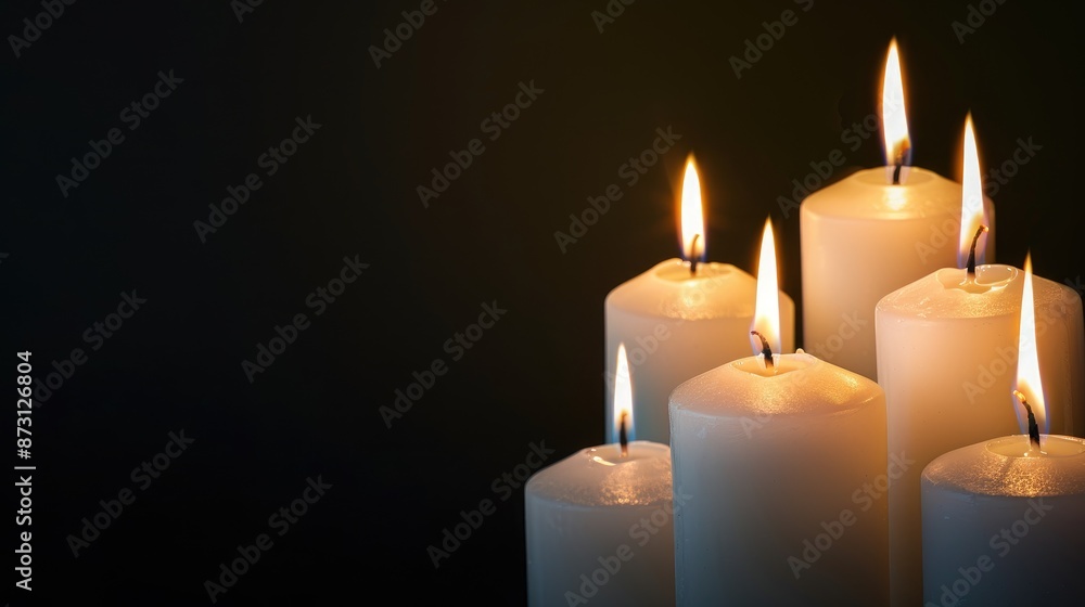 White glowing candles against dark background with copy space White glowing candles against dark background with copy space