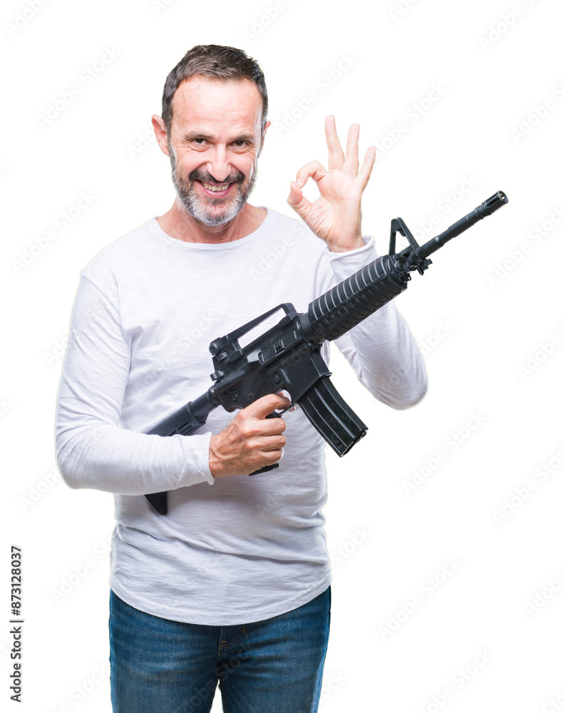 Middle age senior hoary criminal man holding gun weapon over isolated background doing ok sign with fingers, excellent symbol Middle age senior hoary criminal man holding gun weapon over isolated background doing ok sign with fingers, excellent symbol