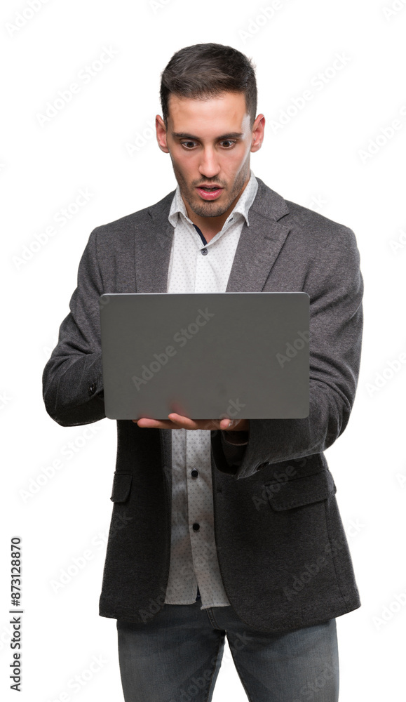 Handsome young man using computer laptop scared in shock with a surprise face, afraid and excited with fear expression Handsome young man using computer laptop scared in shock with a surprise face, afraid and excited with fear expression