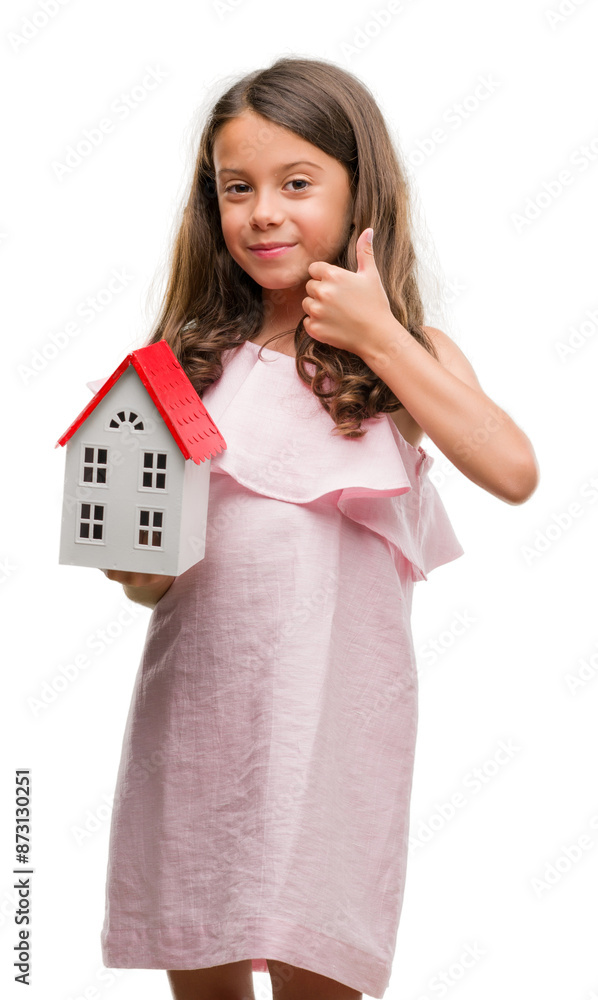 Brunette hispanic girl holding little house happy with big smile doing ok sign, thumb up with fingers, excellent sign Brunette hispanic girl holding little house happy with big smile doing ok sign, thumb up with fingers, excellent sign