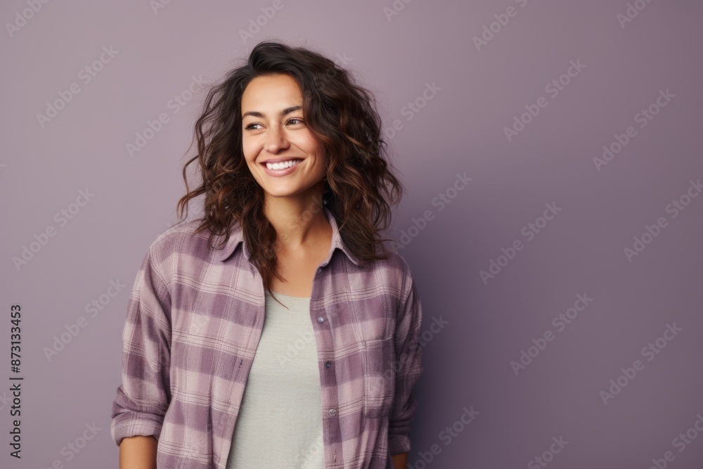Portrait of a happy woman in her 30s wearing a comfy flannel shirt in front of pastel gray background Portrait of a happy woman in her 30s wearing a comfy flannel shirt in front of pastel gray background
