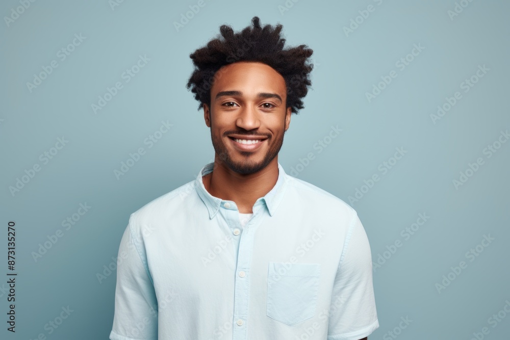 Portrait of a satisfied afro-american man in his 20s wearing a simple cotton shirt in front of pastel gray background Portrait of a satisfied afro-american man in his 20s wearing a simple cotton shirt in front of pastel gray background