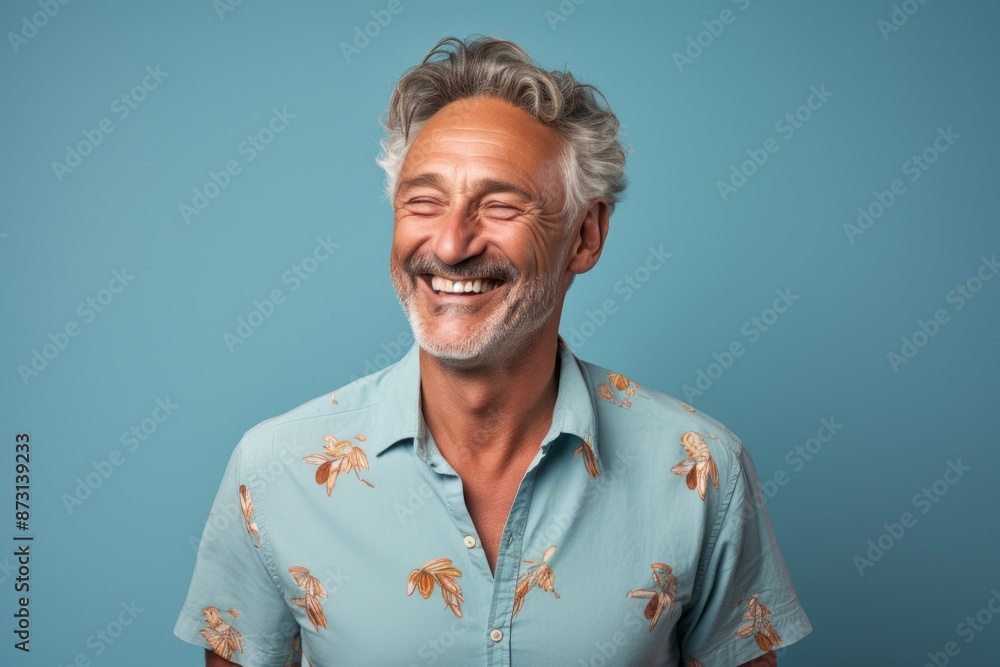 Portrait of a jovial man in his 50s donning a trendy cropped top on soft blue background Portrait of a jovial man in his 50s donning a trendy cropped top on soft blue background