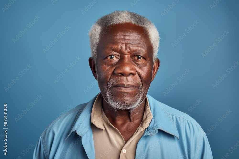 Portrait of a glad afro-american elderly man in his 90s dressed in a water-resistant gilet isolated on soft blue background Portrait of a glad afro-american elderly man in his 90s dressed in a water-resistant gilet isolated on soft blue background