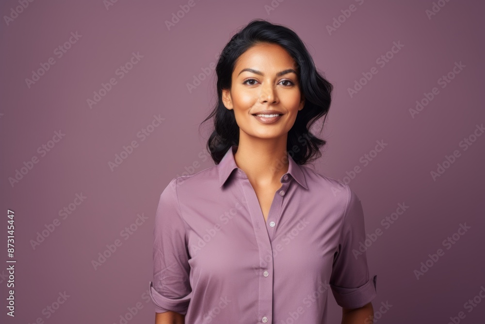 Portrait of a content indian woman in her 30s donning a classy polo shirt while standing against soft purple background Portrait of a content indian woman in her 30s donning a classy polo shirt while standing against soft purple background