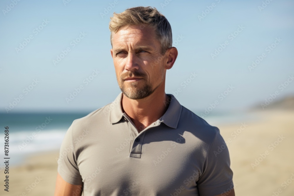 Portrait of a tender man in his 40s donning a classy polo shirt on sandy beach background