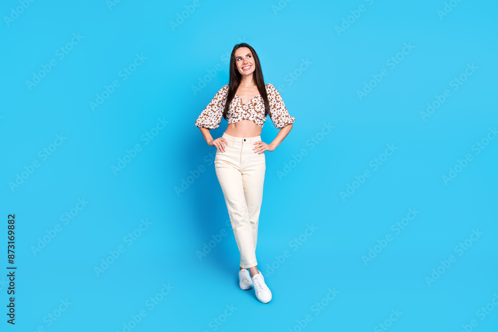 Photo of lovely dreamy nice woman wear stylish print clothes looke empty space isolated on blue color background Photo of lovely dreamy nice woman wear stylish print clothes looke empty space isolated on blue color background