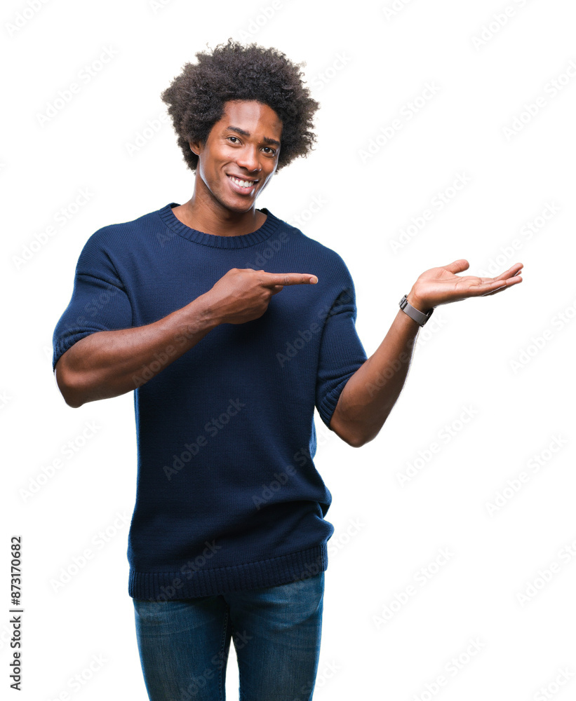 Afro american man over isolated background amazed and smiling to the camera while presenting with hand and pointing with finger. Afro american man over isolated background amazed and smiling to the camera while presenting with hand and pointing with finger.