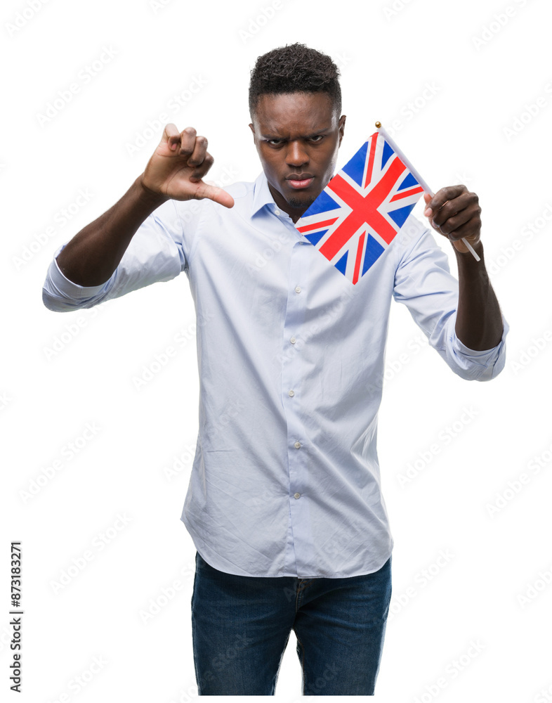 Young african american man holding United Kingdom flag with angry face, negative sign showing dislike with thumbs down, rejection concept Young african american man holding United Kingdom flag with angry face, negative sign showing dislike with thumbs down, rejection concept