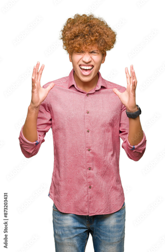 Young handsome business man with afro hair crazy and mad shouting and yelling with aggressive expression and arms raised. Frustration concept. Young handsome business man with afro hair crazy and mad shouting and yelling with aggressive expression and arms raised. Frustration concept.