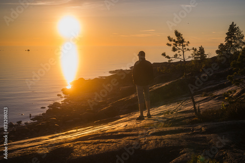 Man watching the sunset by the sea. Fäboda, Finland.