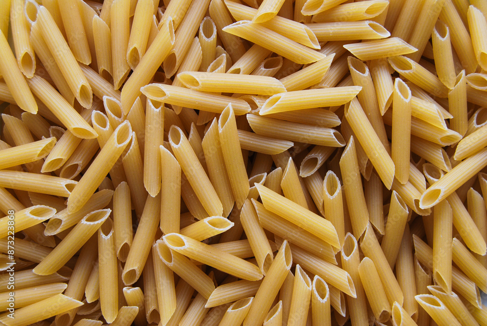 a pile of uncooked penne rigate pasta laid out on a pasta surface a pile of uncooked penne rigate pasta laid out on a pasta surface