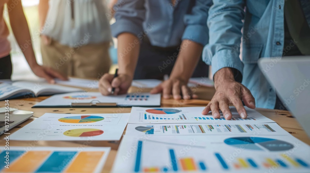 A business team of colleagues meets to plan, strategize, analyze, and discuss new financial graph data in the office. A business team of colleagues meets to plan, strategize, analyze, and discuss new financial graph data in the office.