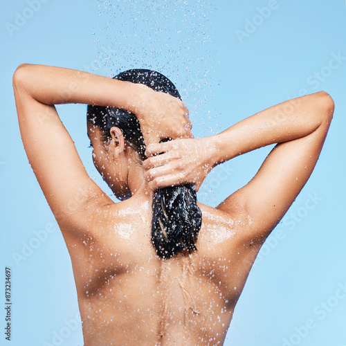 Принти на полотні Woman, back and washing hair in studio, water and blue background for body care or wellness