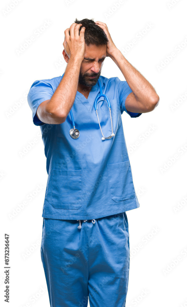 Adult hispanic doctor or surgeon man over isolated background suffering from headache desperate and stressed because pain and migraine. Hands on head. Adult hispanic doctor or surgeon man over isolated background suffering from headache desperate and stressed because pain and migraine. Hands on head.