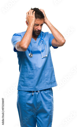 Adult hispanic doctor or surgeon man over isolated background suffering from headache desperate and stressed because pain and migraine. Hands on head.