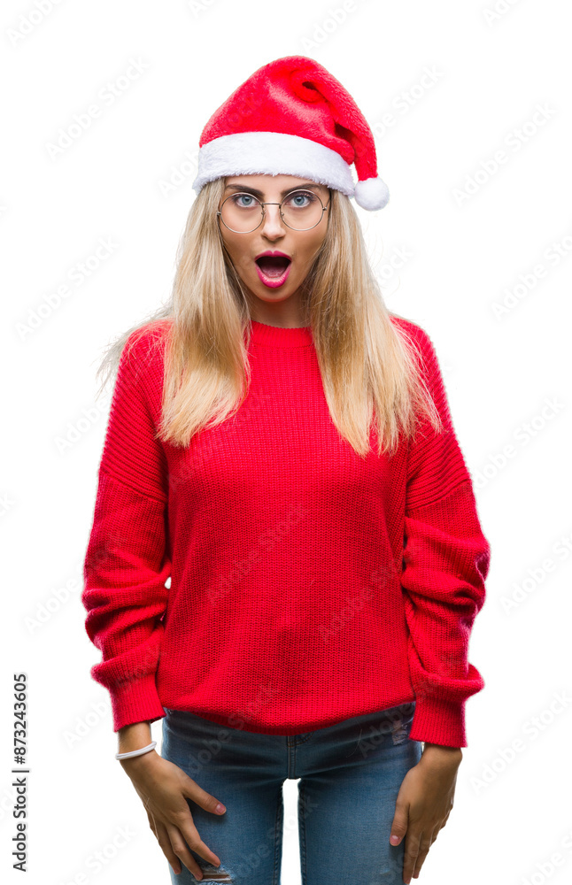 Young beautiful blonde woman wearing christmas hat over isolated background afraid and shocked with surprise expression, fear and excited face. Young beautiful blonde woman wearing christmas hat over isolated background afraid and shocked with surprise expression, fear and excited face.