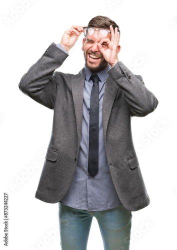 Young handsome business man over isolated background doing ok gesture with hand smiling, eye looking through fingers with happy face.