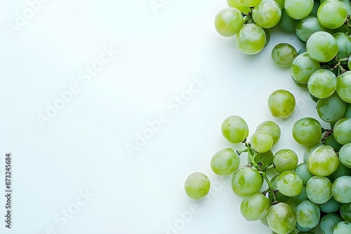 Grains of Shine Muscat grapes and cut Shine Muscat grapes on a white background, showcasing their translucent quality and vibrant green hues, with space for text. photo